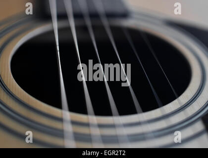 Chitarra acustica dettaglio closeup di stringhe e foro del suono, con fuoco selettivo. Foto Stock