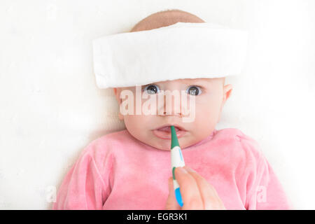 Il medico controlla la temperatura del neonato con un termometro. Un  infermiere in uniforme misura la febbre del bambino con un termometro Foto  stock - Alamy