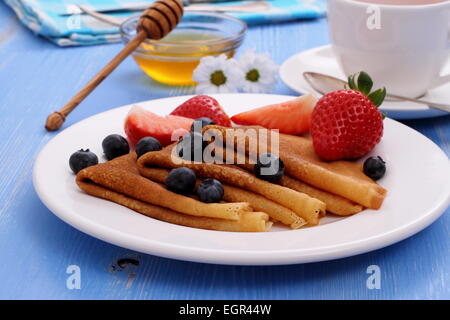 Pila di pancake freschi fragole mirtilli e miele, close up Foto Stock