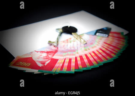 Busta bianca con denaro, chiavi e una carta di credito Foto Stock