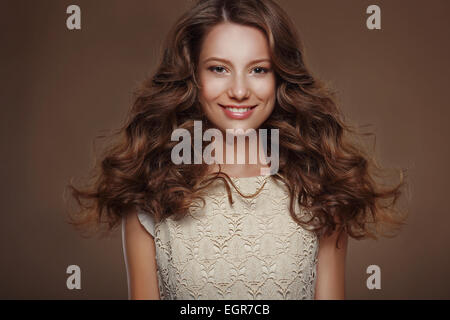 Bella felice bruna con lunghi capelli ricci Foto Stock