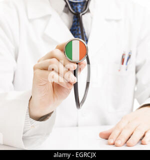 Medico tenendo uno stetoscopio con serie di bandiera - Irlanda Foto Stock