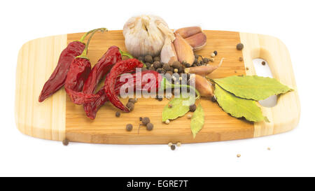Spezie, la foglia di alloro, pepe, peperoncino e cipolla e aglio sul bordo di taglio Foto Stock