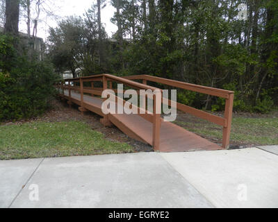 Asse di legno ponte che attraversa il torrente su una registrazione di ghiaia strada nella foresta. Foto scattata su: Febbraio 28th, 2015, Miami, Florida Foto Stock