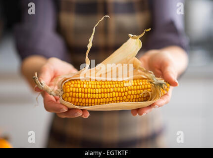 Primo piano sul giovane casalinga che mostra il mais Foto Stock