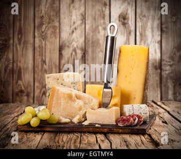 Vari tipi di formaggio servita su un tavolo di legno Foto Stock