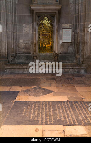 Jane Austen 's grave la pietra in primo piano e la sua successiva parete in ottone memorial, dietro, nella navata centrale della Cattedrale di Winchester. Regno Unito. Foto Stock