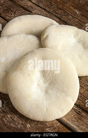 Quattro pagnotte di pane arabo sul tavolo di legno. Foto Stock