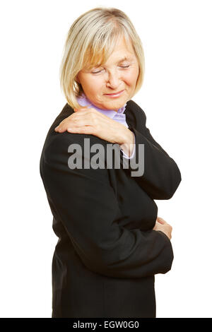 Vecchia donna in un business suit avente dolore alla spalla e tenendo premuto il suo punto dolente Foto Stock