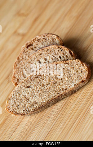 Tre fette di pane di segale su una tavola di legno Foto Stock