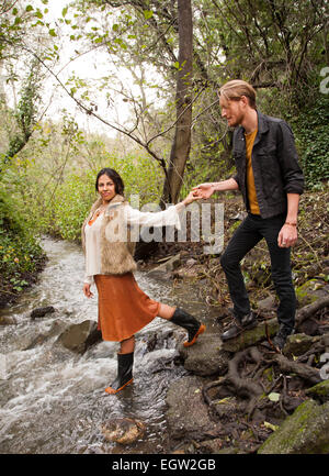 Donna Uomo aiutando attraverso creek. Foto Stock