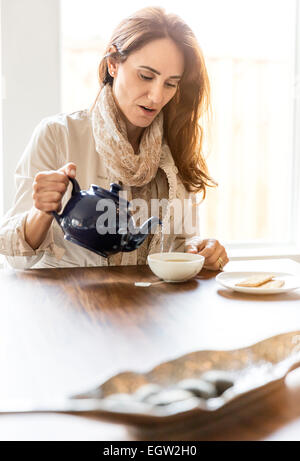 Donna versando il tè. Foto Stock