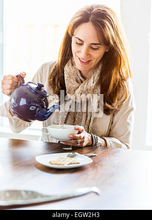 Donna versando il tè. Foto Stock