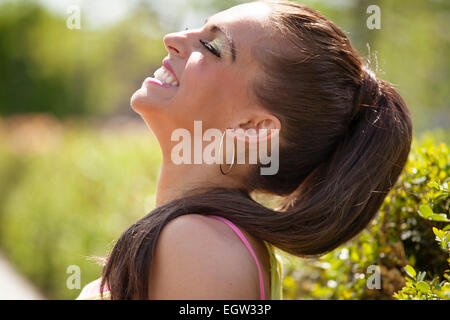 Fino in prossimità del profilo di donna sorridente con la mentoniera sollevata. Foto Stock