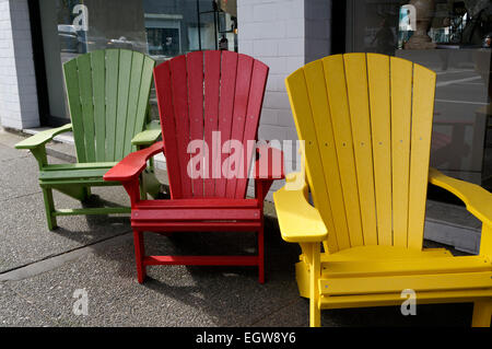 Tre colorate sedie Adirondack in piedi sul marciapiede davanti ad un home decor store Foto Stock