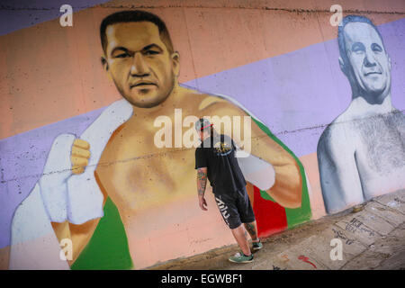 Un grafitti artista dipinge un murale del boxer bulgaro Kubrat Pulev, aka il Cobra, su una parete sotto un ponte a sostegno di imbattuto pesi massimi titolo mondiale lotta contro il campione in carica Wladimir Klitchko. A fianco del Cobra è un ritratto della legenda Foto Stock