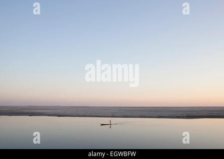 Boatman la polarizzazione sul fiume Brahmaputra al tramonto, Majuli Island, Assam, India Foto Stock