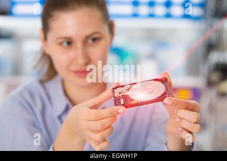 Una studentessa con un hard disk HDD in mani Foto Stock