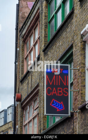 Mini Cabs firmare al di fuori di un edificio nella zona est di Londra, Regno Unito Foto Stock