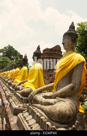 Righe di immagini del Buddha in Wat Yai Chai Mongkol in Ayutthaya in Thailandia Foto Stock