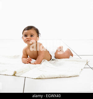 Baby girl nel pannolino giacente sulla pancia, 7 mesi Foto Stock