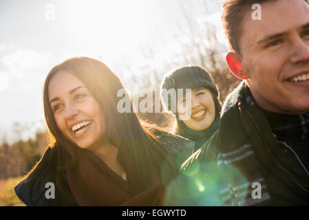 Tre persone, due donne e un uomo in caldi cappotti in una passeggiata. Foto Stock