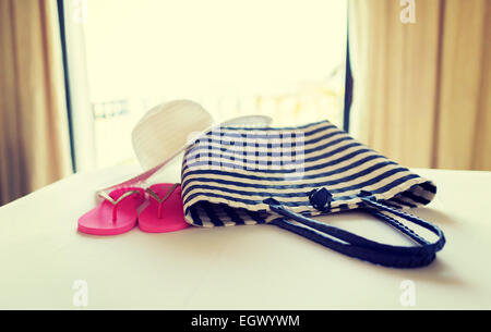 Close-up di borsa da spiaggia, cappello e flip-flop a letto Foto Stock