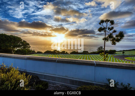 Regolazione del sole attraverso le nuvole sopra l'Oceano Pacifico. Vista da Fort Rosecrans Cimitero Nazionale, San Diego, California, regno Foto Stock