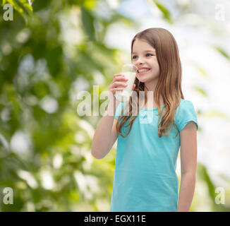 Sorridente bambina bere latte in vetro Foto Stock