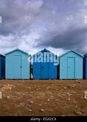 Tradizionale blu dipinto di cabine in legno sotto il cielo tempestoso a Charmouth su Jurassic Coast in Dorset South West England Regno Unito Foto Stock