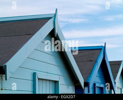 Tradizionale blu dipinto di cabine in legno sotto il cielo blu a Charmouth su Jurassic Coast in Dorset South West England Regno Unito Foto Stock