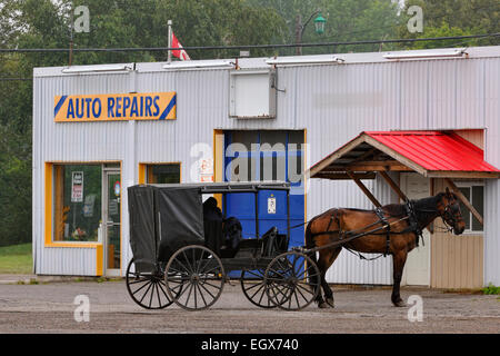 Mennonita cavallo e carrozza parcheggiato di fronte ad un negozio di riparazioni auto ponte di ferro Ontario Canada Foto Stock