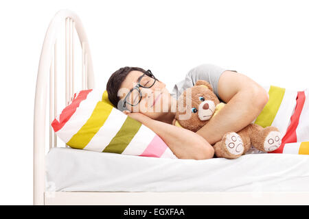 Infantile giovane uomo dorme con un orsacchiotto isolati su sfondo bianco Foto Stock