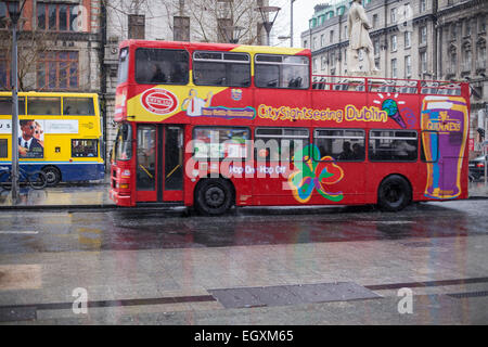 City sightseeing bus su Dublino è O'Connell street sotto la pioggia di domenica Foto Stock