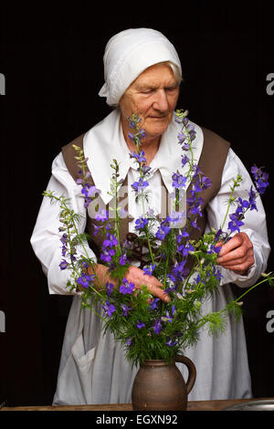 Lady vestita in costume d'epoca che organizza fiori, Hampton Country Life Museum, Jersey, Regno Unito Foto Stock