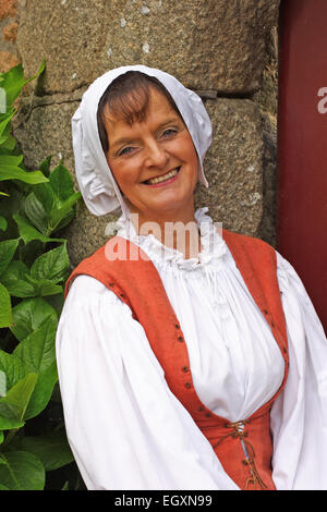 Lady vestita in costume d'epoca, sorridente, Hampton Country Life Museum, Jersey, Regno Unito Foto Stock