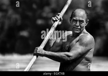 Un colombiano sabbia miner, utilizzando una chiatta pole, naviga la sua barca nel fiume la Vieja in Cartago, Colombia. Foto Stock