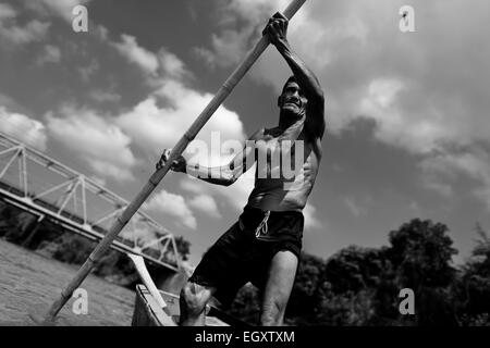 Un colombiano sabbia miner, utilizzando una chiatta pole, naviga la sua barca nel fiume la Vieja in Cartago, Colombia. Foto Stock