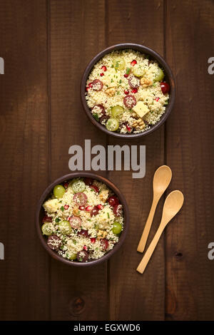 Il cous cous vegetariano con insalata di uva, melograno, noci, formaggio, lime e menta, fotografati con luce naturale Foto Stock