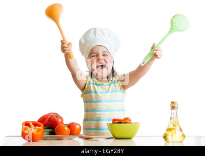 Sorridente bambina in cook hat con la schiumarola e siviera Foto Stock