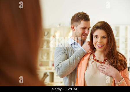 Uomo Donna aiuta con il montaggio di una collana al gioielliere store Foto Stock