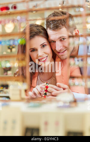 Sorridente giovane acquisto di un bracciale in un negozio Gioielli Foto Stock