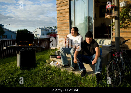 Due giovani uomini sedersi sul retro passo in Fort McMurray. Foto Stock