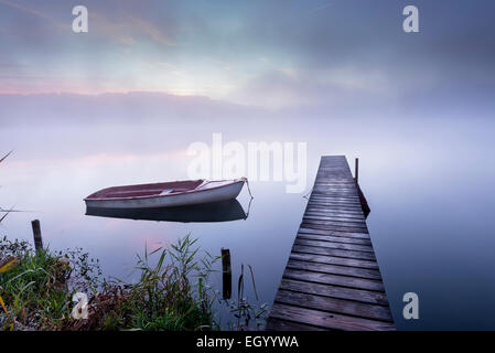 Germania, Wessling, Wesslinger vedere, barca e passerella in legno di mattina nebbia Foto Stock