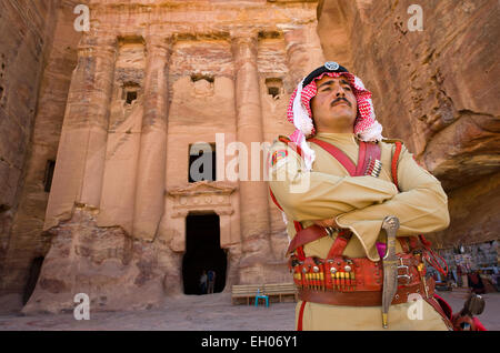 PETRA, GIORDANIA - Ott 12, 2014: una guardia in costume antico di fronte a una delle tombe reali di Petra in Giordania Foto Stock