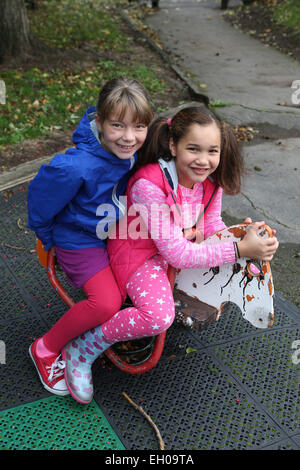 Due ragazze su cavallo a dondolo - modello rilasciato Foto Stock