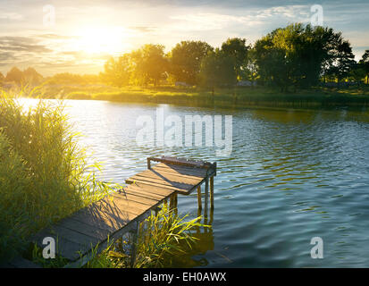 Il molo di legno su un fiume di sera Foto Stock