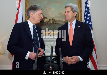 Stati Uniti Il segretario di Stato John Kerry ascolta come Segretario degli esteri britannico Philip Hammond indirizzi reporters dopo arrivò al n. 1 giardini Carlton - il Segretario di Stato per gli affari esteri la residenza ufficiale - a Londra, Regno Unito, il 21 febbraio 2015, per le discussioni si sono incentrate sull'anti-ISIL coalizione e la situazione in Ucraina. Foto Stock