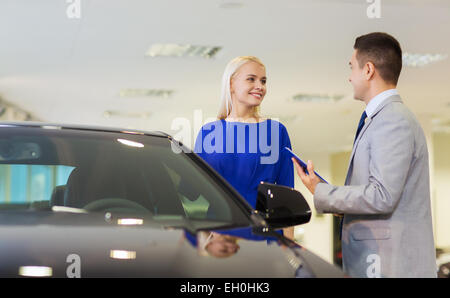 Donna felice con il rivenditore di auto in auto show o salon Foto Stock