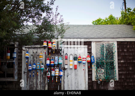 Legno verniciato boe appendere su un edificio con cedro schierata in Rockport, Massachusetts. Foto Stock